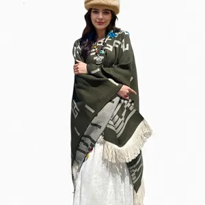 Boho-Strickponcho in Olivgrün mit geometrischem Muster und hellen Fransen am Saum