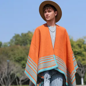 Close-up detail of men's knit poncho featuring orange fabric, blue stripes and fringe