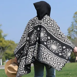 Rückansicht eines Herren Kapuzen Strickponchos mit geometrischem Stammesmuster in Schwarz Weiß