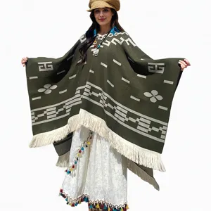 Vorderansicht des grünen Strickponchos mit geometrischen Mustern und Fransen
