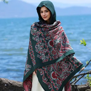 Detailansicht eines dunkelgrünen Strickschals mit Kapuze und rotem Paisleymuster