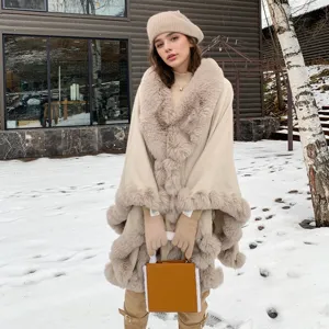 Elegant beige faux fur collar cape shawl worn by a model in a snowy outdoor setting