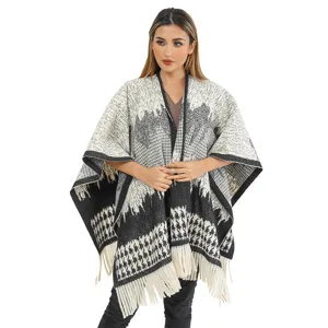 Detailed look at a warm houndstooth knit shawl with elegant fringes for winter