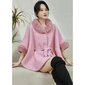 Detail shot of pink faux mink fur cape with plush collar and belted waist for women.