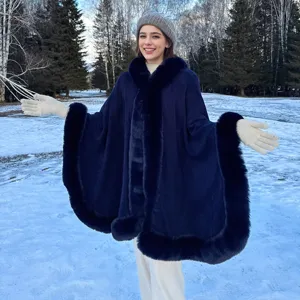 Mannequin portant un poncho tricoté bleu marine avec bordure en fourrure en forêt