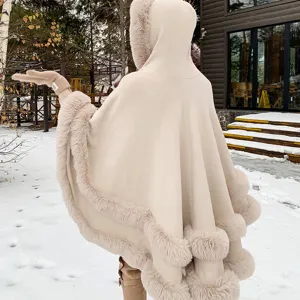 Vue arrière d'une élégante cape en maille à capuche pour femme avec bordure en fausse fourrure