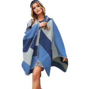 Full view of a stylish hooded knit poncho featuring a blue and grey color-block pattern.
