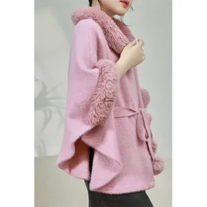Detail shot of a pink faux mink fur poncho with a large collar and waist belt.