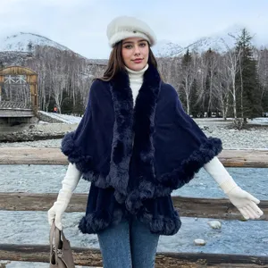 Elegant navy blue knit cape with luxurious faux fur collar and trim for winter styling