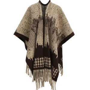 Close-up of a warm knitted houndstooth poncho featuring elegant fringe tassels for winter.