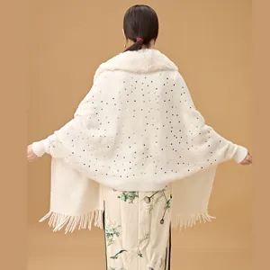 Detailed back view of white knit shawl with sequins, fur collar and fringe tassels