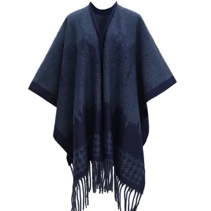 Close-up detail of a thickened navy and blue houndstooth knitted poncho with elegant tassels