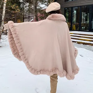 Back view of elegant pink faux fur trimmed cape shawl in a snowy landscape.