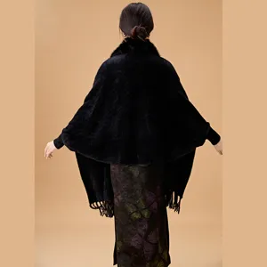 Vista trasera detallada de un elegante chal negro de imitación visón con cuello de piel y flecos