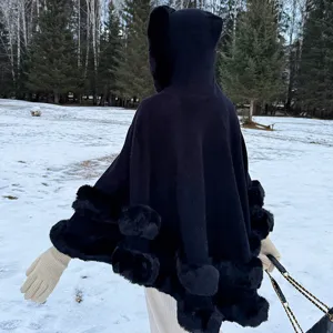 Vue détaillée d'un poncho en tricot à capuche noir avec bordure en fourrure