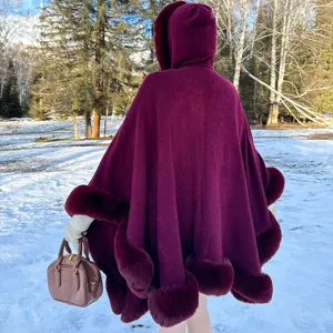 Vue arrière d'un poncho en maille bordeaux avec capuche et bordure en fausse fourrure