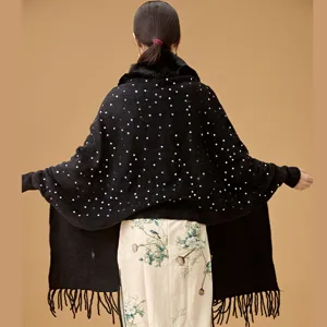 Rear view detail of black knitted sequin shawl with elegant fur collar and fringe