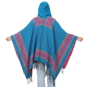 Vue arrière d'un poncho en tricot bleu à capuche avec motifs de cœurs roses et franges