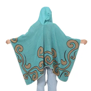 Detailansicht der Rückseite eines türkisfarbenen Strickponchos mit Kapuze und Wirbelmuster