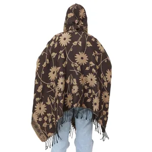 Back view of brown knit hooded poncho with floral sunflower pattern and tassels
