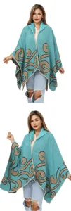 Detailansicht des türkisfarbenen Damen-Strickponchos mit kunstvollen braunen Wirbelmustern