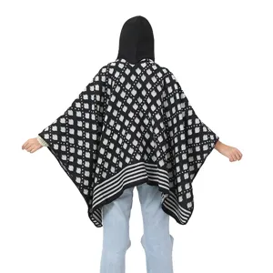 Back view of a black and white geometric patterned hooded poncho shawl for women