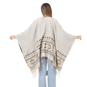 Back view of bohemian knitted poncho with ethnic geometric pattern and fringe details.
