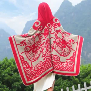 Rückansicht eines rot-beigen Kapuzen-Ponchos mit traditionellem Drachenmuster aus Strick.
