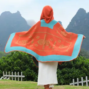 Detaillierte Rückansicht eines Strick-Ponchos mit Kapuze und Ethno-Muster in Orange.