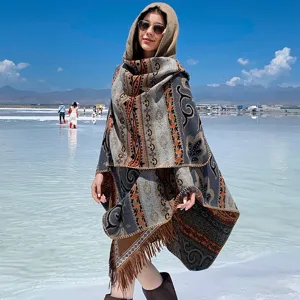 Detailansicht eines dicken Winter-Ponchos mit Kapuze, ethnischem Muster und Fransen