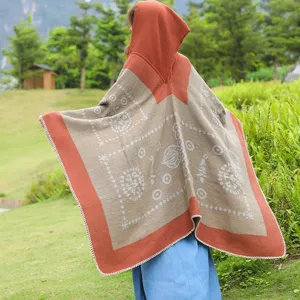 Rückansicht eines modischen Kapuzen-Strickponchos mit ethnischen Mustern für Damen.