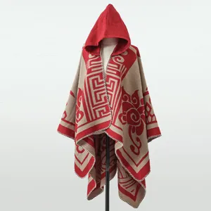 Detail eines gestrickten Kapuzenponchos mit roten geometrischen Mustern auf Beige.