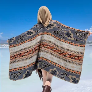 Rückansicht eines kapuzen-ponchos mit ethnischem muster und quasten