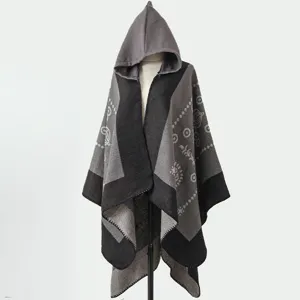 Modisches grau-schwarz gestricktes Kapuzen-Poncho-Tuch mit Ziermustern auf einer Schneiderpuppe