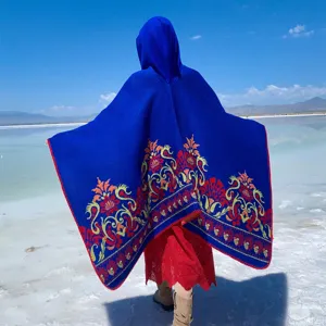Detailed back view of a hooded blue knitted shawl with ethnic floral patterns