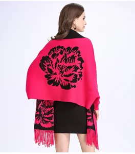 Nahaufnahme eines pinken Jacquard-Strickschals mit schwarzem Blumenmuster und Fransen