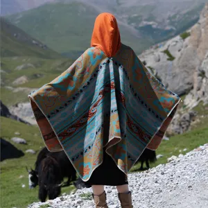 Rückansicht eines farbenfrohen Kapuzenponchos im Boho-Stil in einer Berglandschaft
