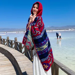 Stylisches rotes Poncho-Cape mit Kapuze und ethnischem Muster für warme Winterreisen