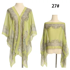 Detailansicht des grünen Chiffon-Schals mit Paisley-Muster und Perlenknöpfen.