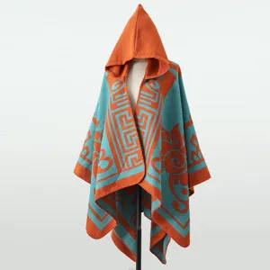 Detailansicht eines Strickponchos mit Kapuze und orange-türkisen geometrischen Mustern.