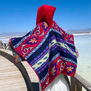 Rückansicht eines dicken Strickponchos mit Kapuze und bunten Boho-Mustern für Auslandsreisen