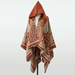 Detailaufnahme eines gestrickten Kapuzenponchos mit orangefarbenen geometrischen Mustern