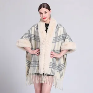 Detailansicht eines eleganten karierten Ponchos mit Plüsch-Kunstfellkragen und Fransensaum
