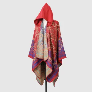 Detalle de un cálido poncho rojo con capucha y elegantes estampados de cachemir vintage