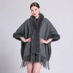 Detailansicht eines grauen Kunstpelzkragens und Fransensaums an einem warmen Winter-Poncho