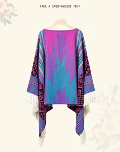 Detailansicht eines böhmischen Strickponchos mit ethnischen Mustern und weißen Fransen