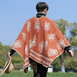 Rückansicht eines rostorangen Strickponchos für Herren mit weißen Blumenmustern und Fransen