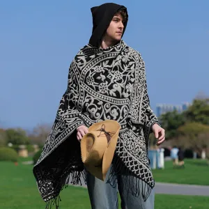 Gestrickter Herren-Poncho mit Kapuze und schwarz-weißem Muster in der Natur