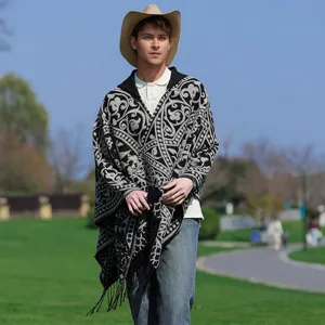 Detail eines Herren-Strickponchos mit Kapuze, ethnischem Schwarz-Weiß-Muster und Fransen