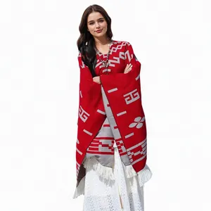 Detailansicht eines roten Strickponchos für Damen mit stilvollen Mustern und Fransen
